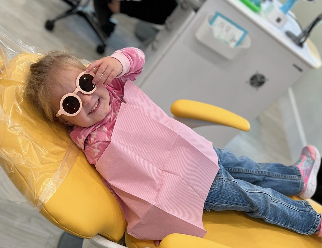Birds eye view of young girl leaning back in dental chair